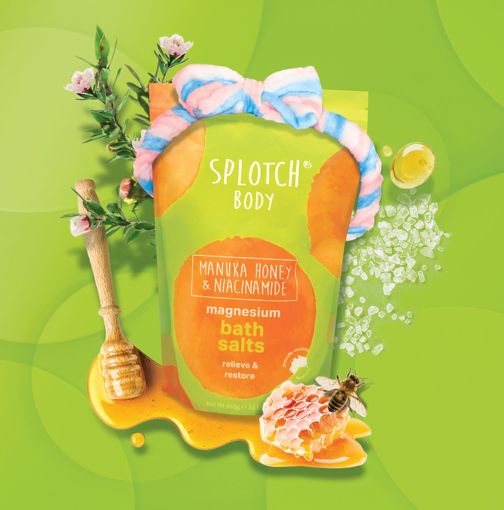 A lime green pouch of magnesium bath salts decorated with a plush pink and blue striped headband. The scene includes a honey dipper, honeycomb, a honeybee, and crystals of sea salt.
