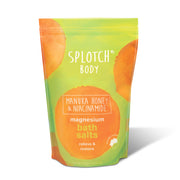 A 950g (33.51 oz) stand-up pouch of Splotch Body "magnesium bath salts". The packaging follows the brand's lime green and orange watercolor aesthetic. The label highlights Manuka Honey & Niacinamide and notes the product's function is to "relieve & restore". A "proudly made in Australia" logo is featured prominently on the lower right.