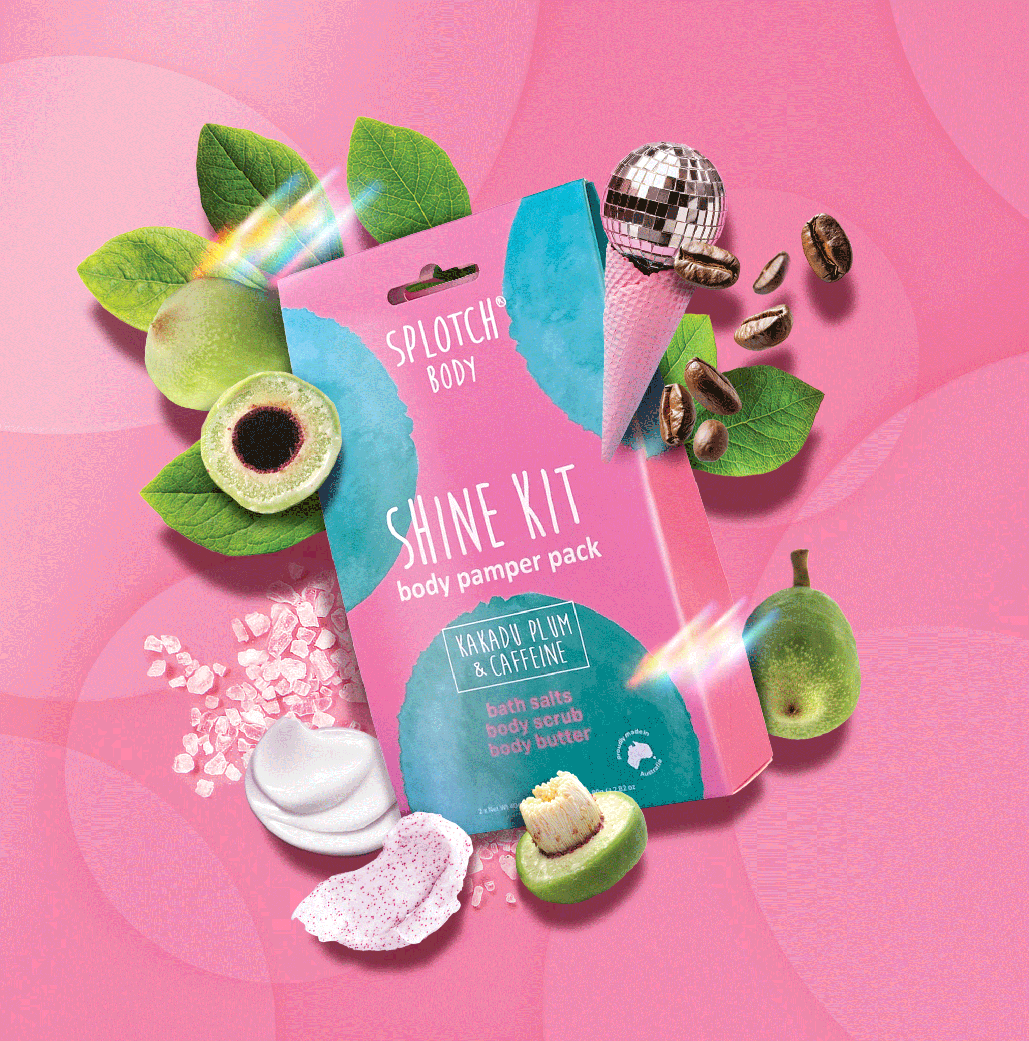 
A marketing product shot for the SPLOTCH BODY SHINE KIT body pamper pack featuring a pink and teal pouch on a pink background. The pouch is labeled "KAKADU PLUM & CAFFEINE" and contains bath salts, body scrub, and body butter.